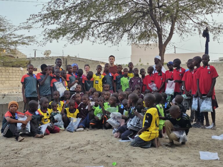 Les enfants et les membres de l'association posent avec les nouveaux maillots.